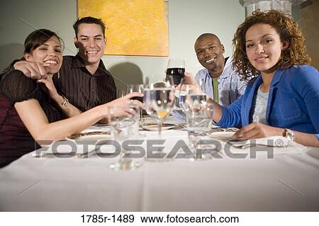 Portrait of two smiling young couples sitting at a restaurant table drinking wine View Large Photo Image Stock Photo - Portrait of two smiling young couples sitting at a restaurant table drinking wine. Fotosearch