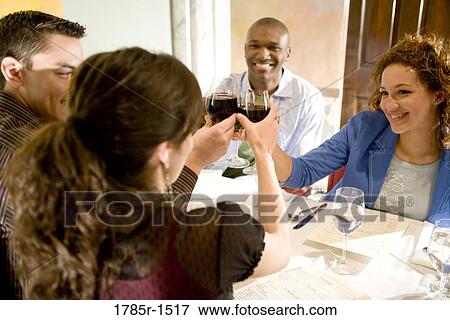 Portrait of two smiling young couples sitting at a restaurant table toasting wine View Large Photo Image Stock Photo - Portrait of two smiling young couples sitting at a restaurant table toasting wine. Fotosearch