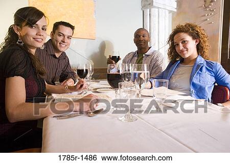 Portrait of two smiling young couples at a restaurant table drinking wine View Large Photo Image Stock Photograph - Portrait of two smiling young couples at a restaurant table drinking wine. Fotosearch