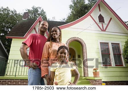 Portrait of young family standing in front of house View Large Photo Image Stock Image - Portrait of young family standing in front of house. Fotosearch