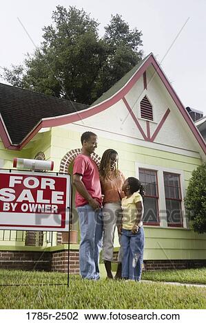 Portrait of young family standing outside house by "For Sale" sign View Large Photo Image Stock Image - Portrait of young family standing outside house by "For Sale" sign. Fotosearch