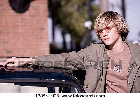 Portrait of young man in vintage 1960's hippie costume standing by a car View Large Photo Image Stock Photo - Portrait of young man in vintage 1960's hippie costume standing by a car. Fotosearch