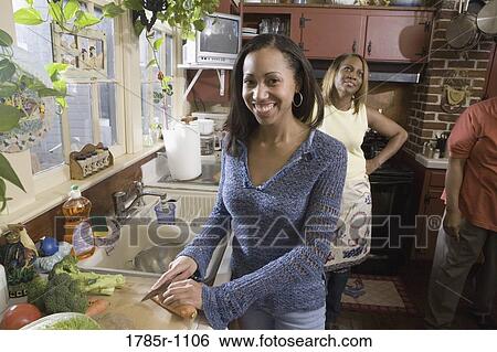 Portrait of young woman cutting vegetables in kitchen View Large Photo Image Stock Photograph - Portrait of young woman cutting vegetables in kitchen. Fotosearch