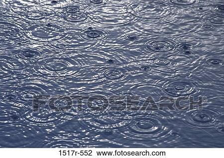 Stock Image - Rain falling on the surface of water. Fotosearch
