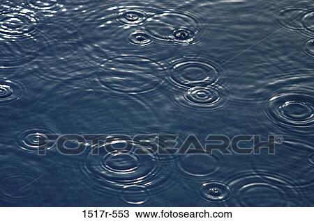 Stock Image - Rain falling on the surface of water. Fotosearch