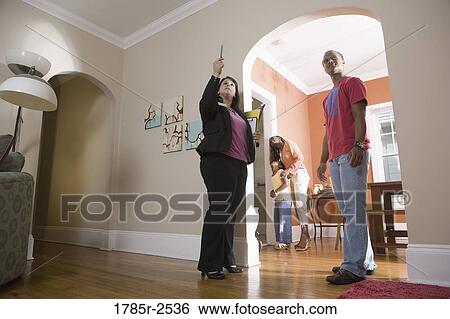 Real estate broker showing house to buyers View Large Photo Image Stock Photograph - Real estate broker showing house to buyers. Fotosearch