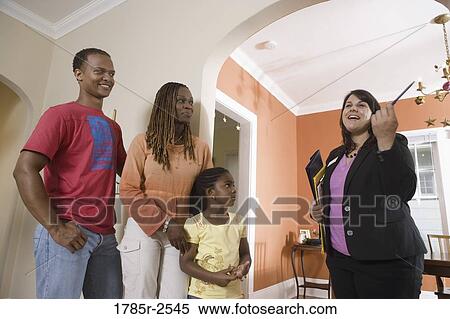 Stock Photography - Real estate broker showing house to buyers. Fotosearch