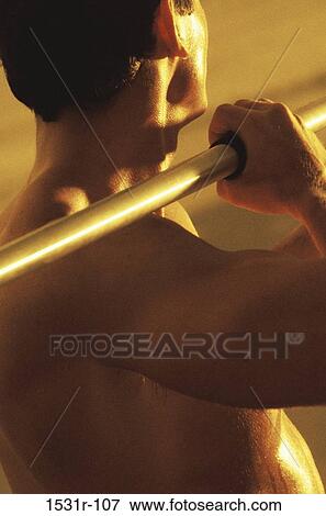 Rear view of a young man holding a javelin View Large Photo Image Stock Photo - Rear view of a young man holding a javelin. Fotosearch