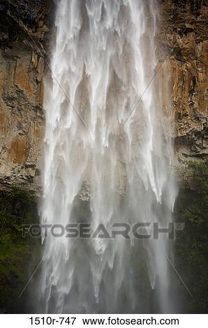 Stock Photo - Rushing waterfall over cliff face. Fotosearch