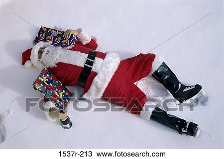 Santa Claus lying down in snow with gifts View Large Photo Image Stock Image - Santa Claus lying down in snow with gifts. Fotosearch