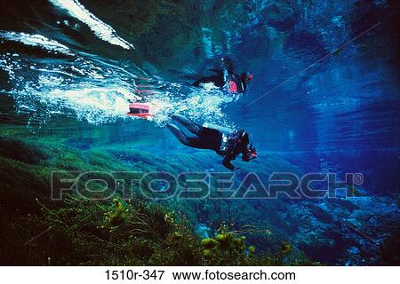 Stock Photo - Scuba diver swimming near a coral reef. Fotosearch