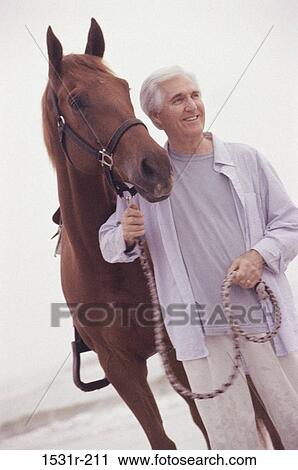 Senior man standing with a horse View Large Photo Image Stock Image - Senior man standing with a horse. Fotosearch
