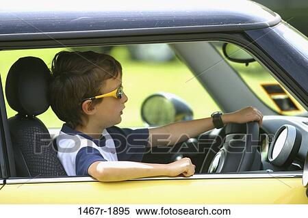 Stock Photography - Side profile of a boy sitting in a car. Fotosearch