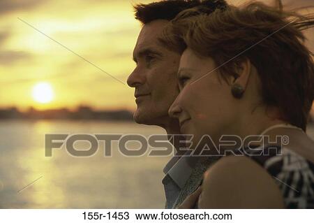 Stock Image - Side profile of a mid adult couple. Fotosearch