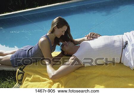 Stock Photography - Side profile of a young couple looking at each other. Fotosearch