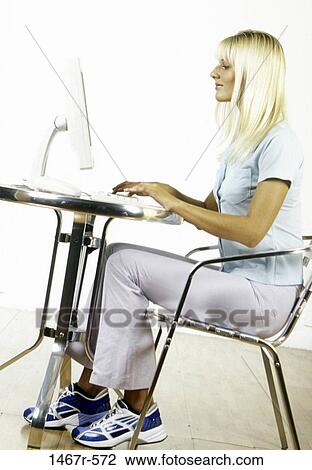 Side profile of a young woman sitting using a laptop View Large Photo Image Stock Image - Side profile of a young woman sitting using a laptop. Fotosearch