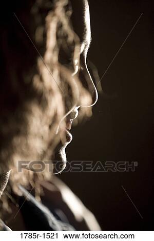 Side view of a silhouetted smiling young woman in a dark room View Large Photo Image Stock Image - Side view of a silhouetted smiling young woman in a dark room. Fotosearch