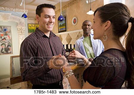 Stock Image - Smiling young couple holding hands. Fotosearch