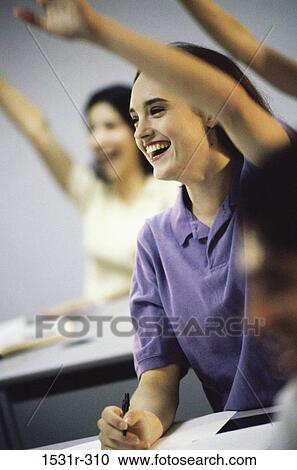 Stock Image - Students raising their hands in class. Fotosearch