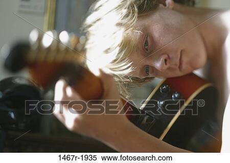 Stock Photography - Teenage boy playing the guitar. Fotosearch