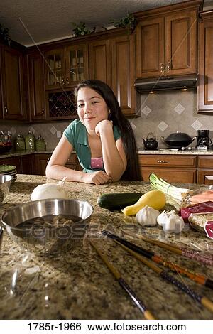Teenage girl in kitchen with ingredients for Asian-style dish View Large Photo Image Stock Photograph - Teenage girl in kitchen with ingredients for Asian-style dish. Fotosearch