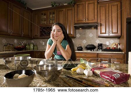 Teenage girl in kitchen with ingredients for Asian-style dish View Large Photo Image Stock Photography - Teenage girl in kitchen with ingredients for Asian-style dish. Fotosearch