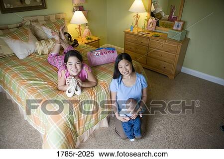Teenage girl lying on bed in bedroom with mom and baby brother View Large Photo Image Stock Photography - Teenage girl lying on bed in bedroom with mom and baby brother. Fotosearch