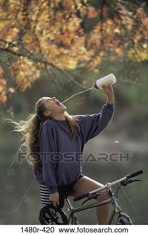 Stock Image - Teenage girl sitting on a bicycle. Fotosearch