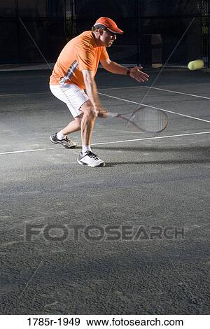 Tennis player hitting a volley at the service line View Large Photo Image Stock Photo - Tennis player hitting a volley at the service line. Fotosearch