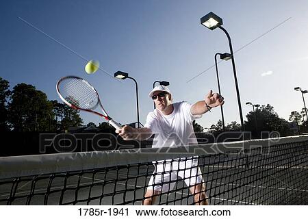 Stock Image - Tennis player hitting a volley. Fotosearch