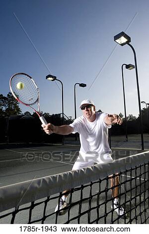 Tennis player hitting a volley View Large Photo Image Stock Image - Tennis player hitting a volley. Fotosearch