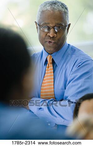 Two businessmen conversing View Large Photo Image Picture - Two businessmen conversing. Fotosearch