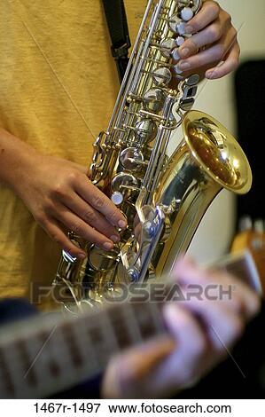 Two people playing a guitar and a saxophone View Large Photo Image Stock Photo - Two people playing a guitar and a saxophone. Fotosearch