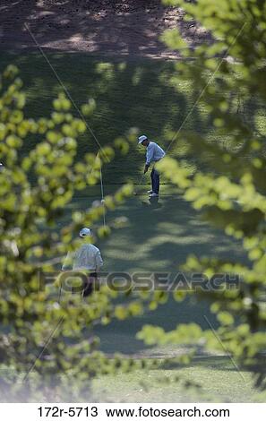 Stock Image - Two people playing golf. Fotosearch