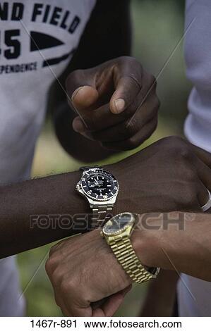 Two people synchronizing their wristwatches View Large Photo Image Stock Image - Two people synchronizing their wristwatches. Fotosearch