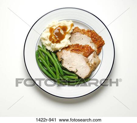 Stock Image - Two slices of turkey, green beans and mashed potatoes with brown gravy on plate. Fotosearch