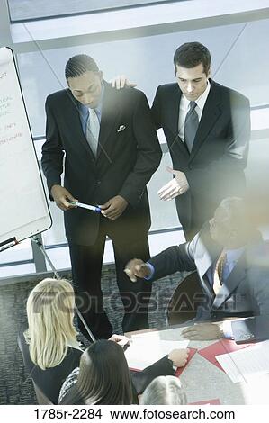 Two young businessmen giving presentation to executives View Large Photo Image Picture - Two young businessmen giving presentation to executives. Fotosearch