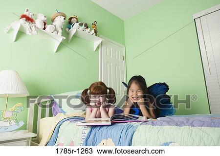 Two young girls in costumes on bed View Large Photo Image Stock Image - Two young girls in costumes on bed. Fotosearch
