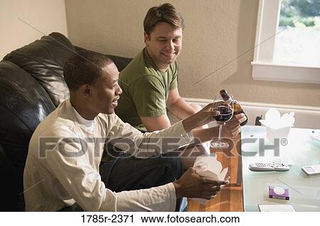 Two young men hanging out at home View Large Photo Image Stock Image - Two young men hanging out at home. Fotosearch