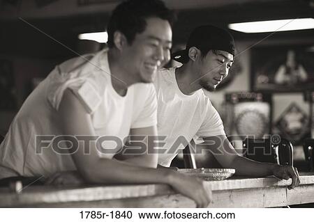Two young men in jeans and t-shirts smiling View Large Photo Image Stock Image - Two young men in jeans and t-shirts smiling. Fotosearch
