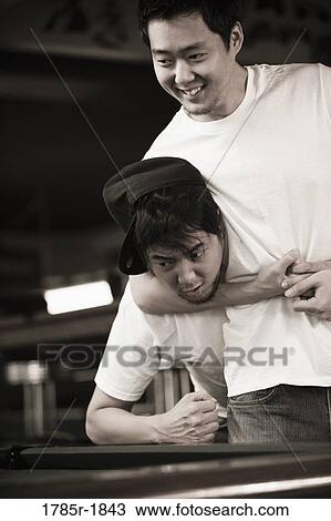 Stock Image - Two young men in jeans and t-shirts fighting. Fotosearch