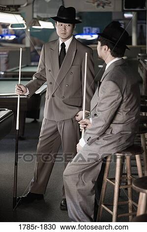 Two young men in suits and hats talking in billiards room View Large Photo Image Stock Image - Two young men in suits and hats talking in billiards room. Fotosearch