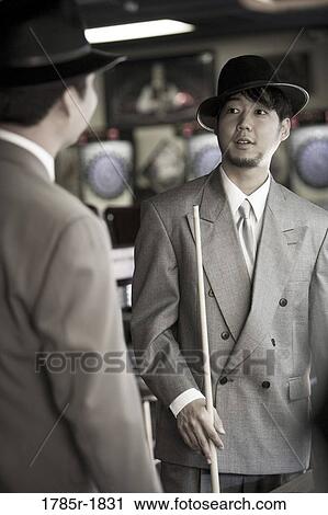 Two young men in suits and hats talking in billiards room View Large Photo Image Stock Image - Two young men in suits and hats talking in billiards room. Fotosearch