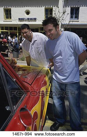 Picture - Two young men looking at a car. Fotosearch