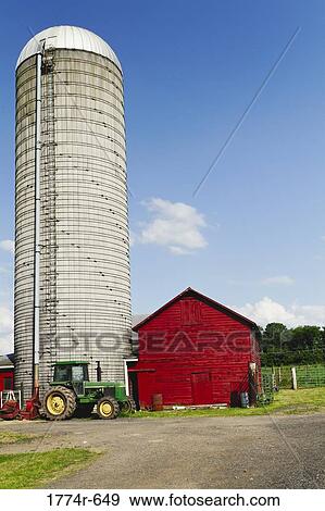 Stock Photo - USA, New Jersey, Hunterdon County, Tractor parked in front of silo and barn at farm. Fotosearch
