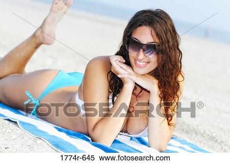 USA, New Jersey, Ocean City, Portrait of smiling young woman in bikini lying on beach View Large Photo Image Stock Photography - USA, New Jersey, Ocean City, Portrait of smiling young woman in bikini lying on beach. Fotosearch