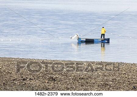 Stock Photo - USA, Washington, Seabeck, Fisherman in boat on Hood Canal. Fotosearch