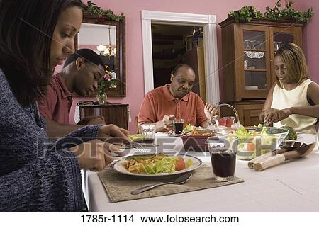 View of a family at dining table View Large Photo Image Picture - View of a family at dining table. Fotosearch