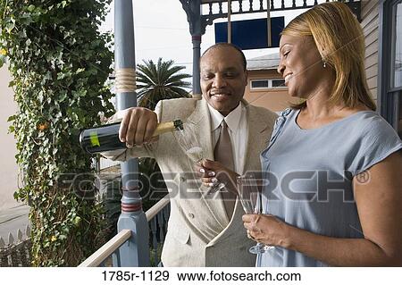 Stock Photo - View of a mature couple celebrating with champagne. Fotosearch