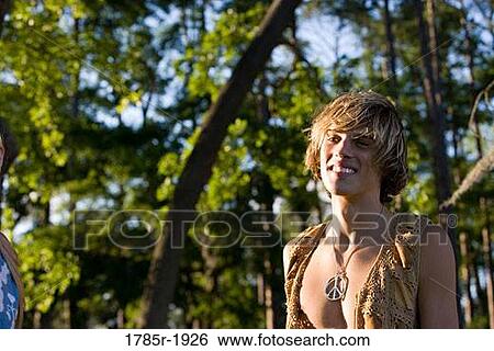 Stock Photograph - View of a smiling young man in vintage 1960's hippie costumes. Fotosearch